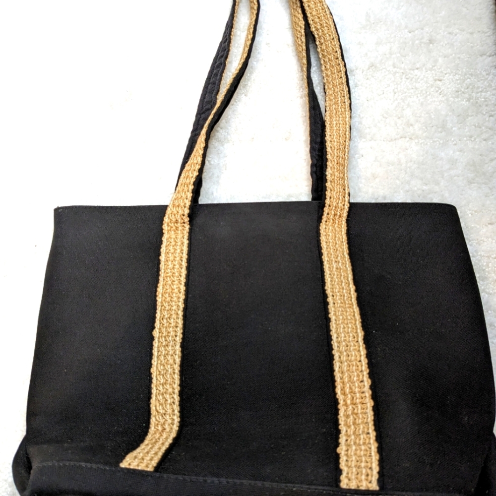 Black canvas tote with hemp- like straps. Checkered inside with zipper pocket.